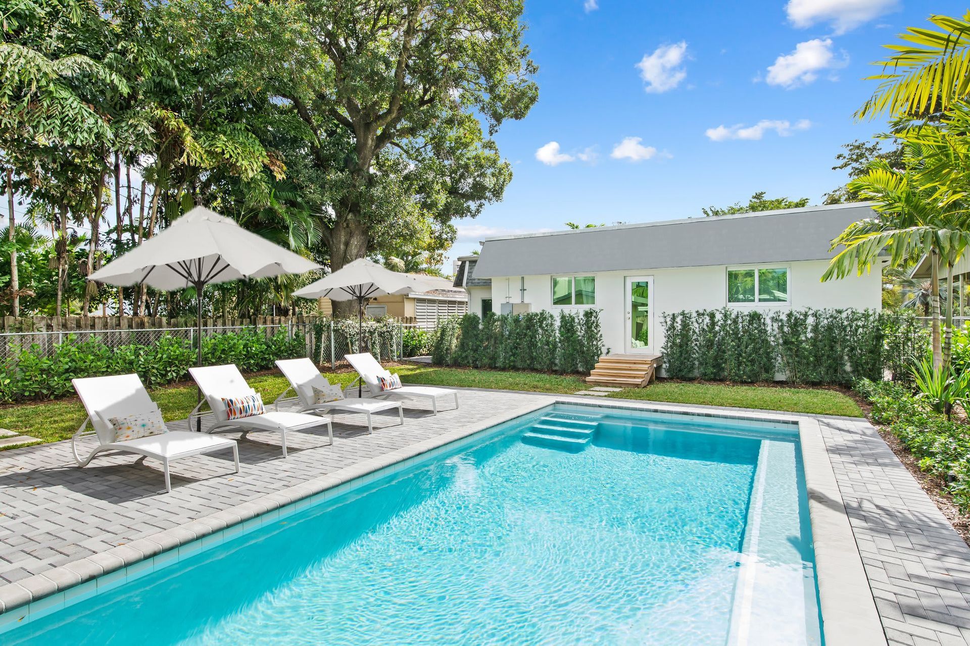 An aerial view of a beach with a red arrow pointing to a house.