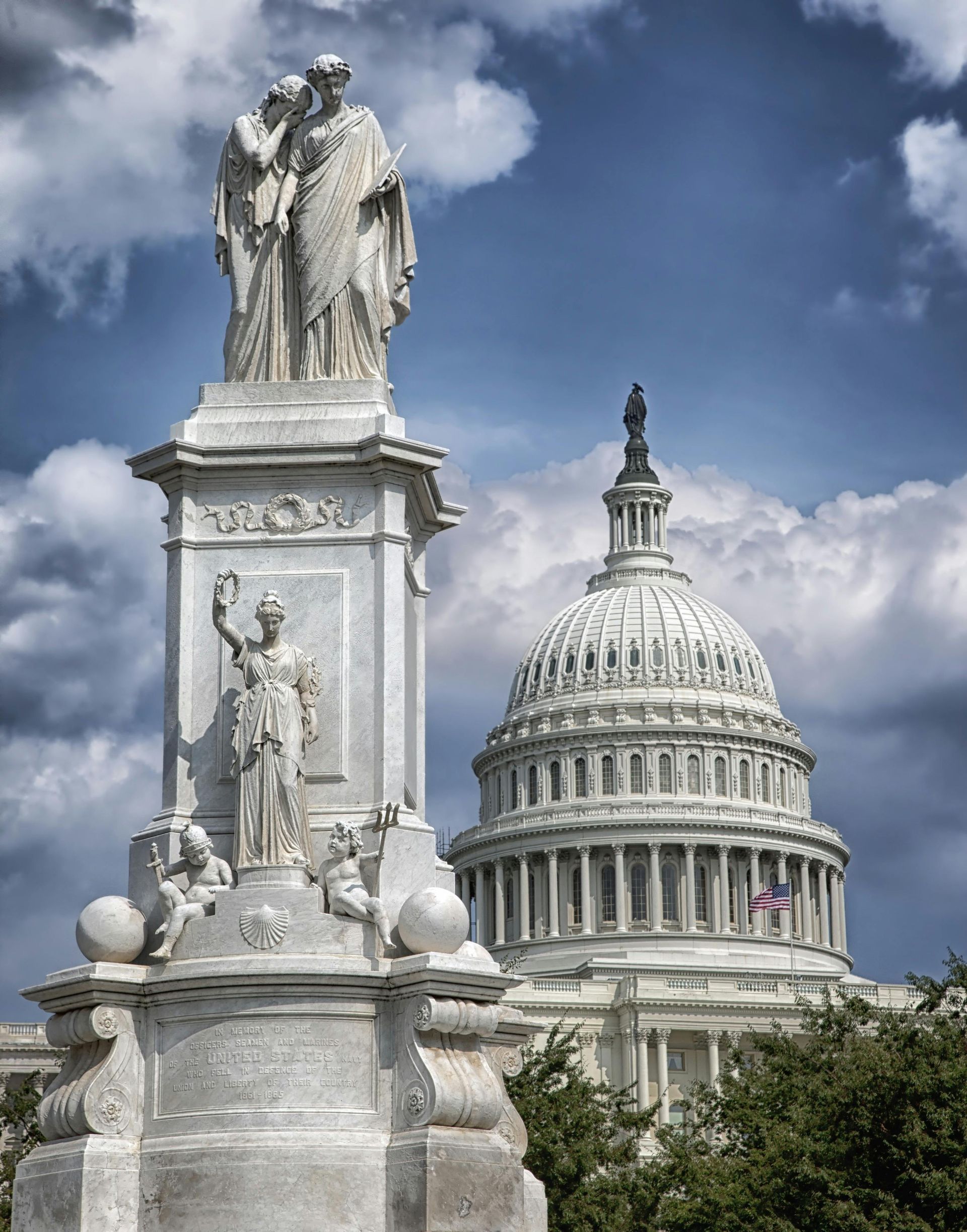 Statue in front of the U.S. Capitol dome on a partly cloudy day.