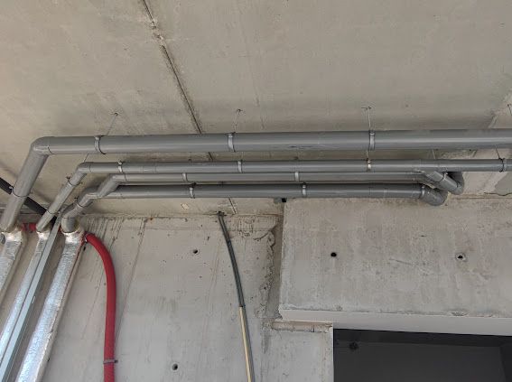 Er hangen een aantal buizen aan het plafond van een gebouw.