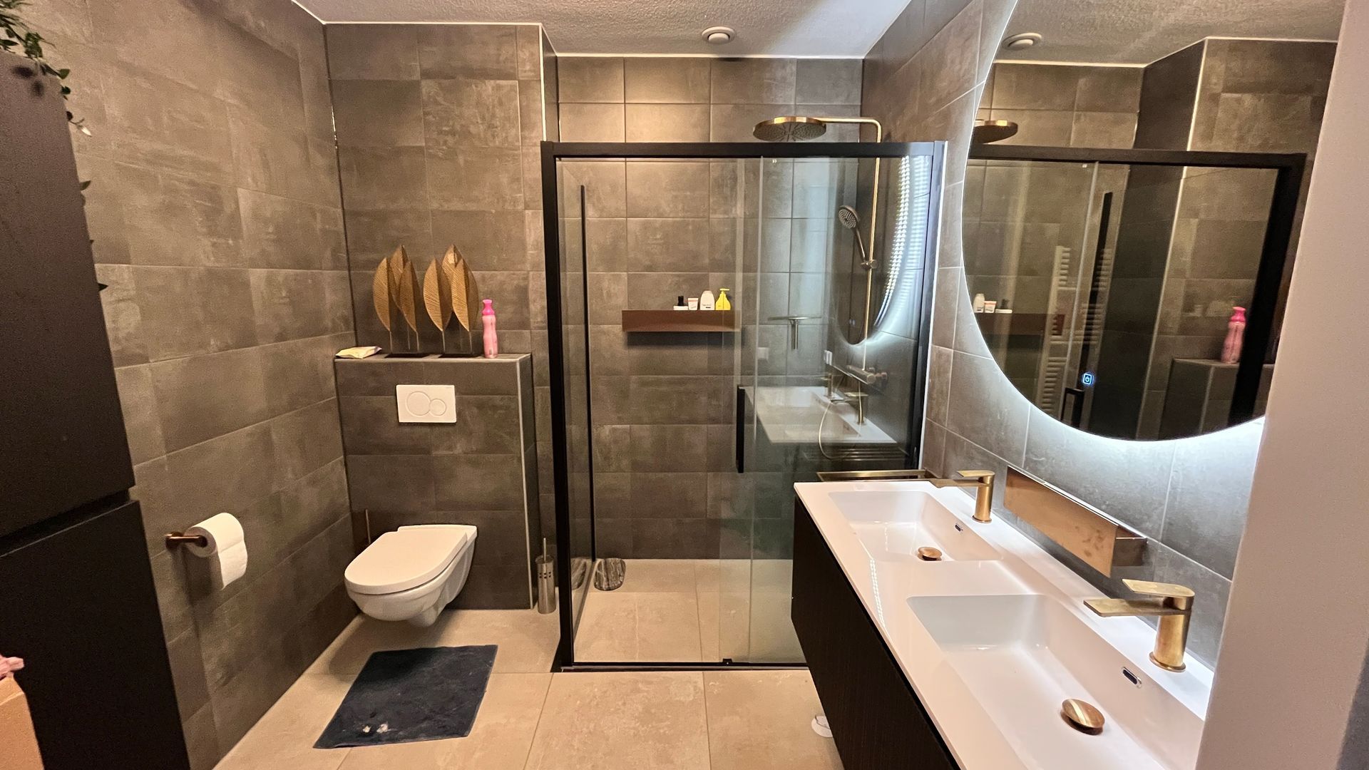 Een badkamer met toilet, wastafel en douche.