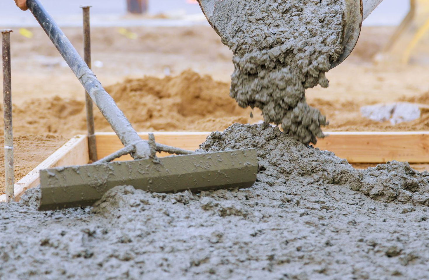 A large house with two garage doors and a concrete driveway.
