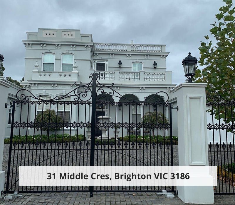 A large white house with a wrought iron gate in front of it