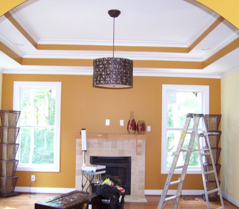 A living room with yellow walls and a fireplace