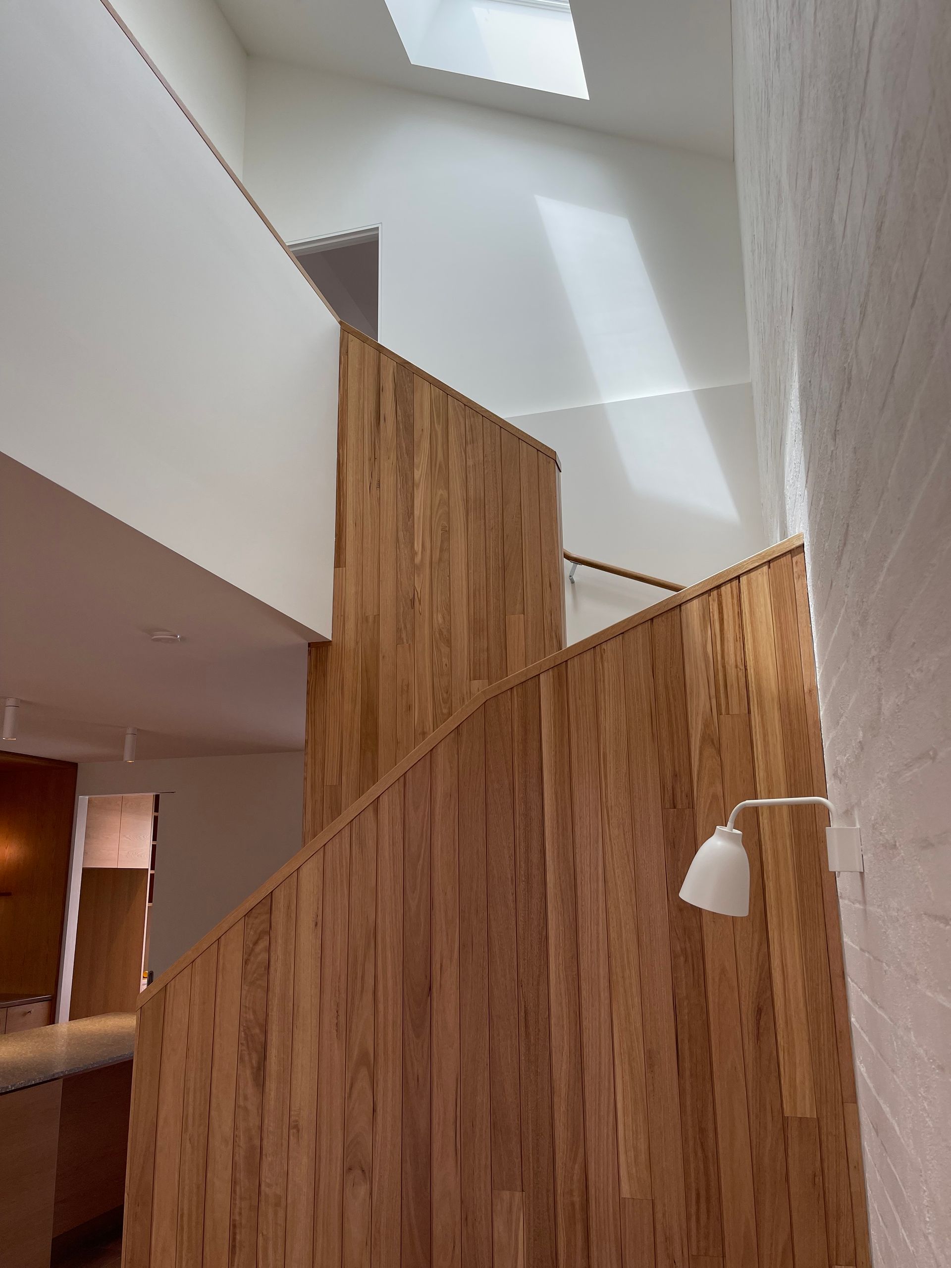 A wooden staircase with a white lamp hanging from it