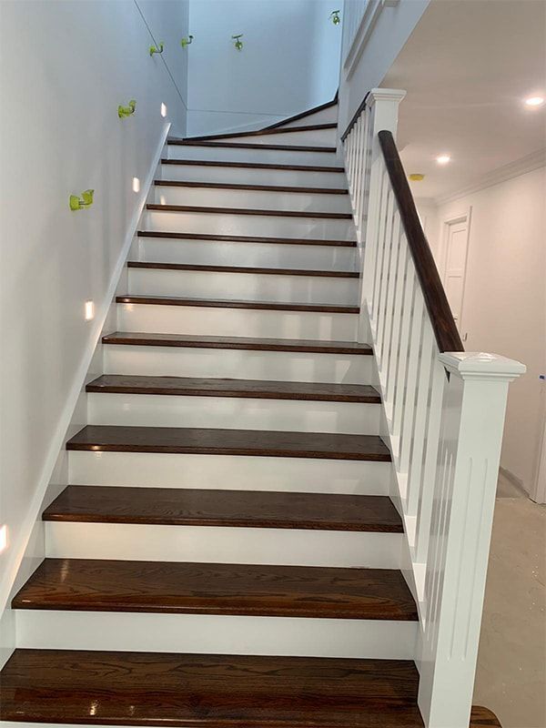 A set of stairs with wooden steps and a white railing.
