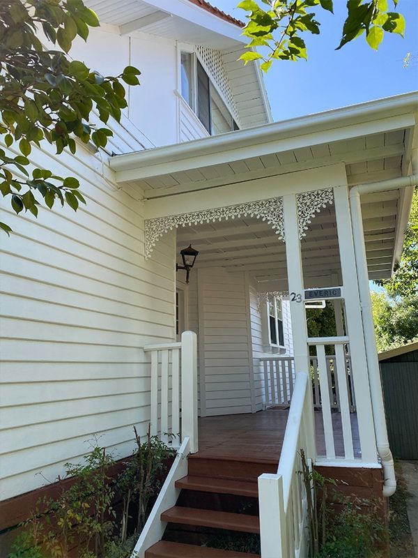 A white house with a porch and stairs leading up to it