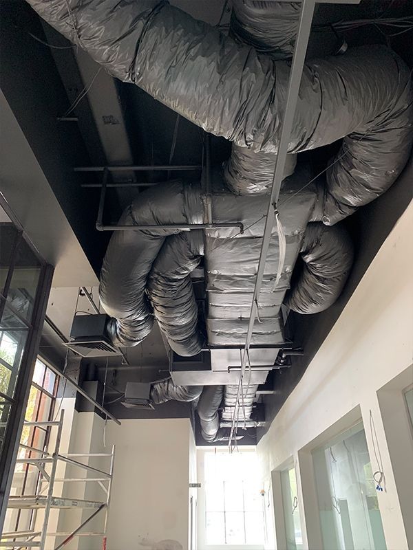 A bunch of pipes are hanging from the ceiling of a building.