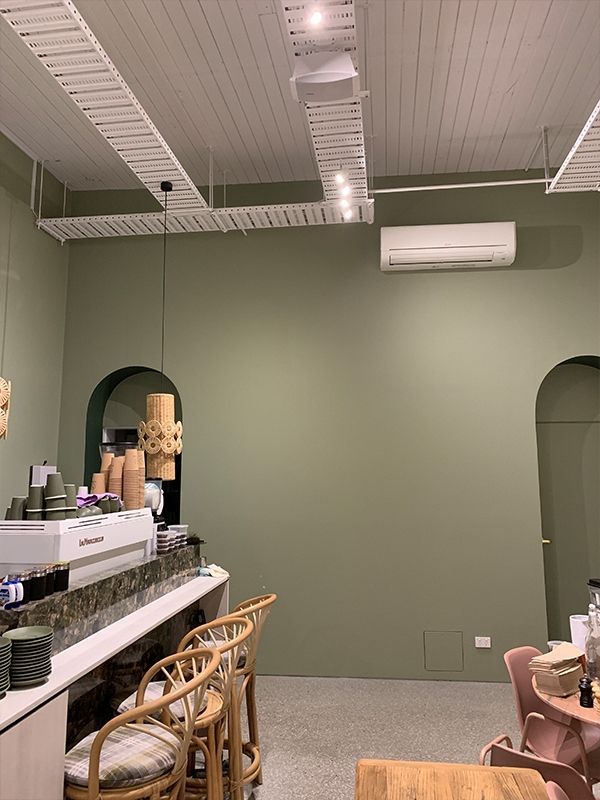 A restaurant with green walls and a white ceiling.