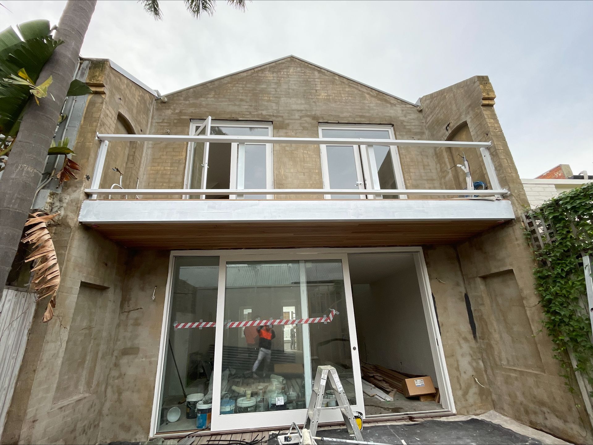 The back of a building with a balcony and sliding glass doors.