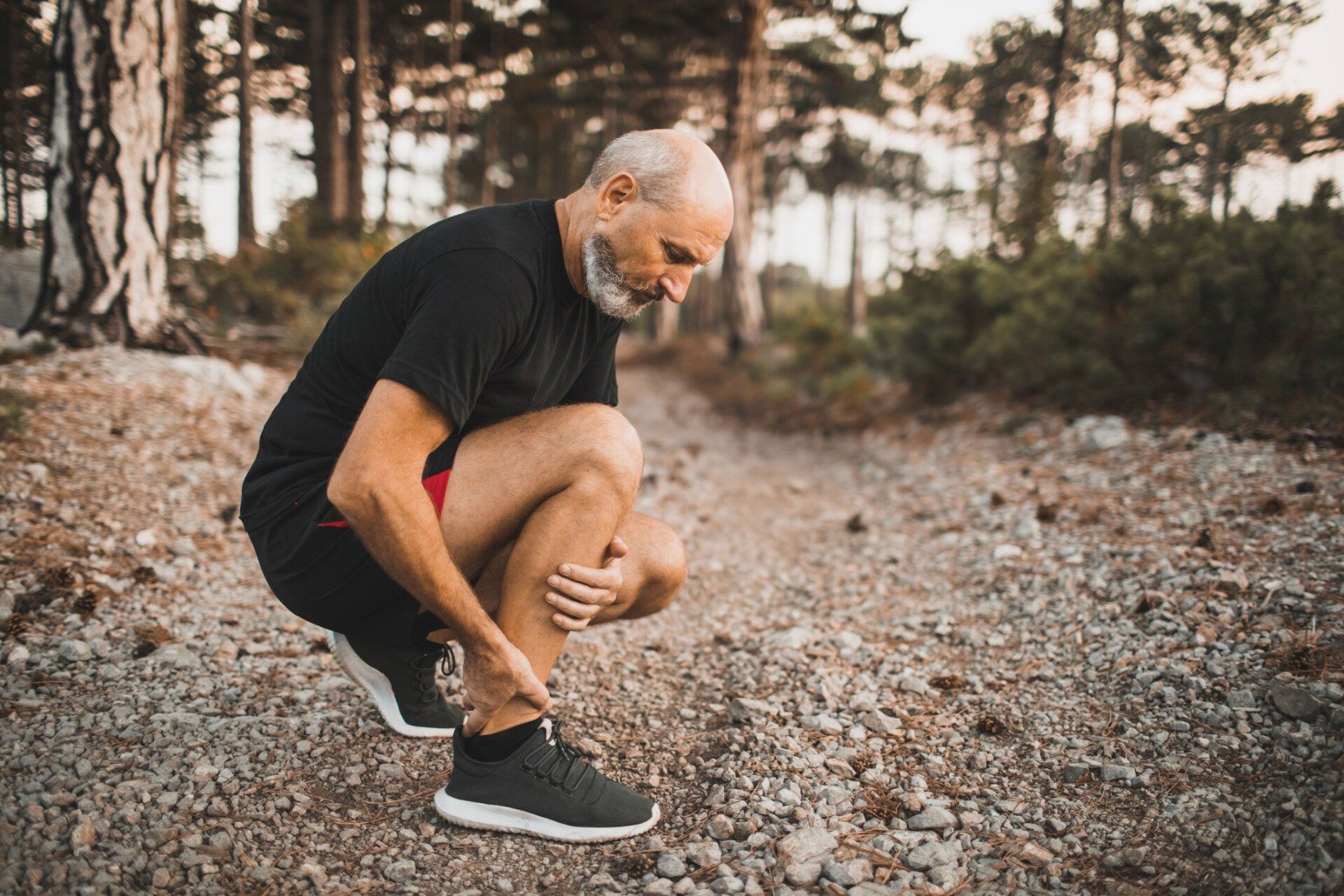 Old man holding ankles — Greenville, SC — Greenville Podiatry Associates, PA
