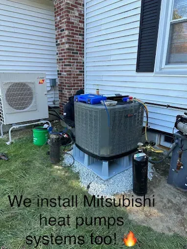 HVAC technician working on an outdoor air conditioner unit next to a white house. A Mitsubishi heat pump is visible, and the text states 