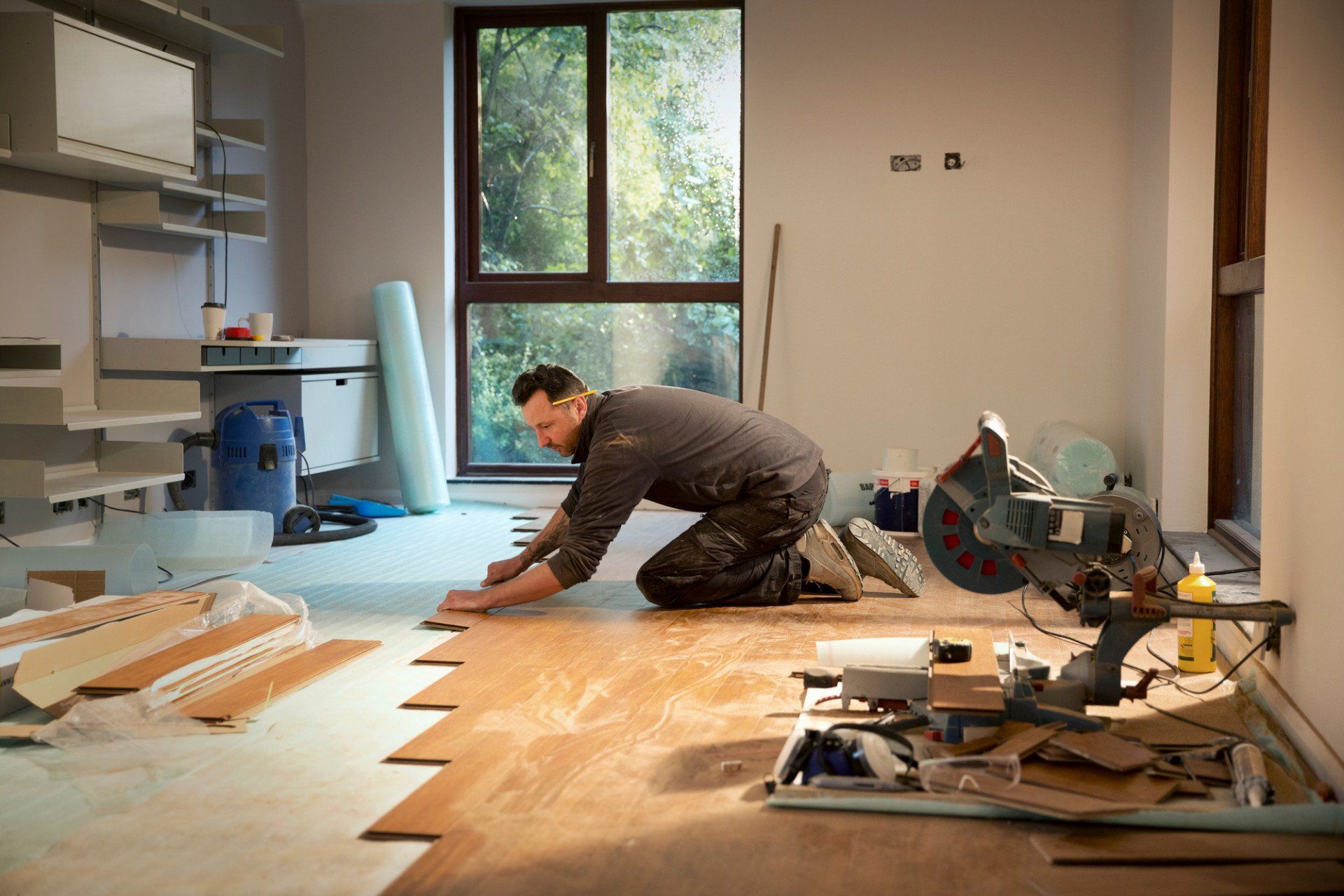 man laying wood flooring