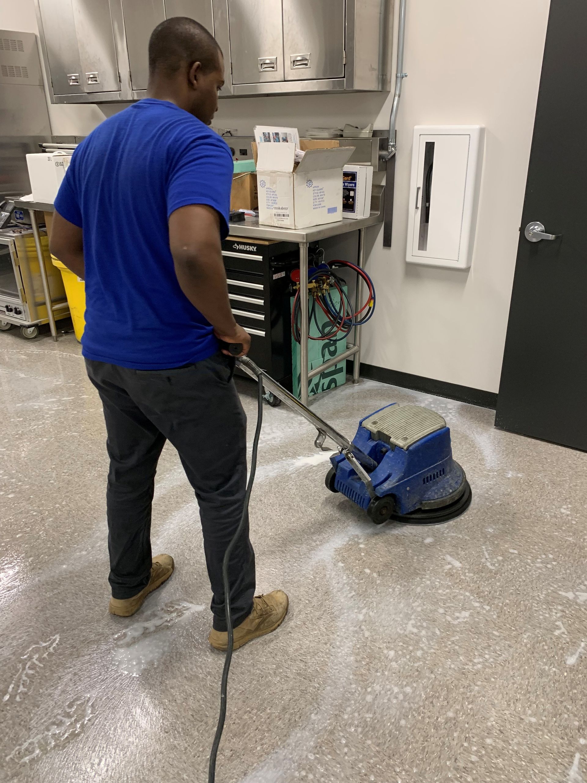 Diamond-patterned tile floor in a diner with red stools, grey chairs, and tables.