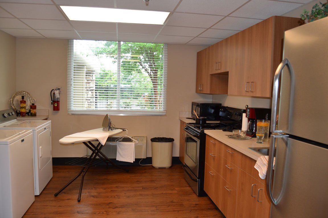 A kitchen with a stove , refrigerator , washer and dryer
