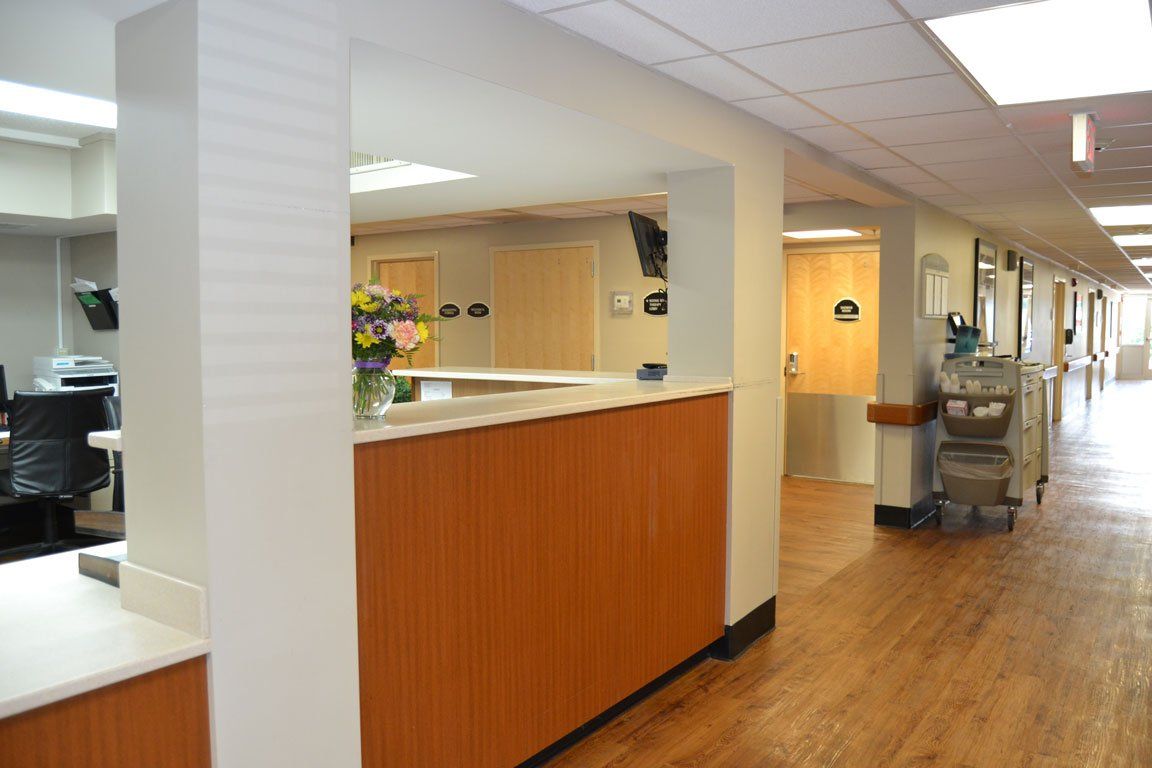 A nurse 's station in a hospital with a vase of flowers on it.
