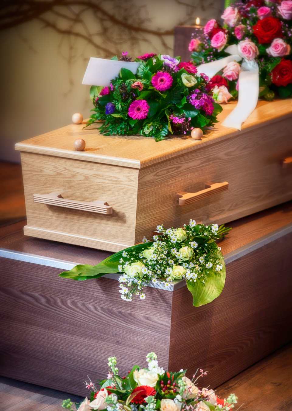 cofano funebre in legno chiaro con fiori