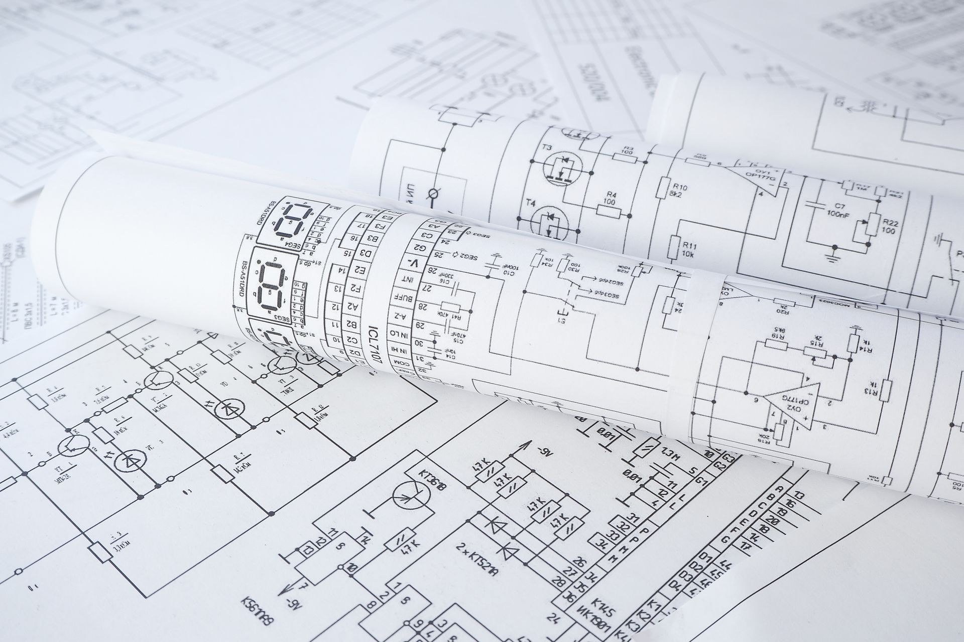 Rolled blueprints of an electrical circuit diagram, with visible components and wiring.