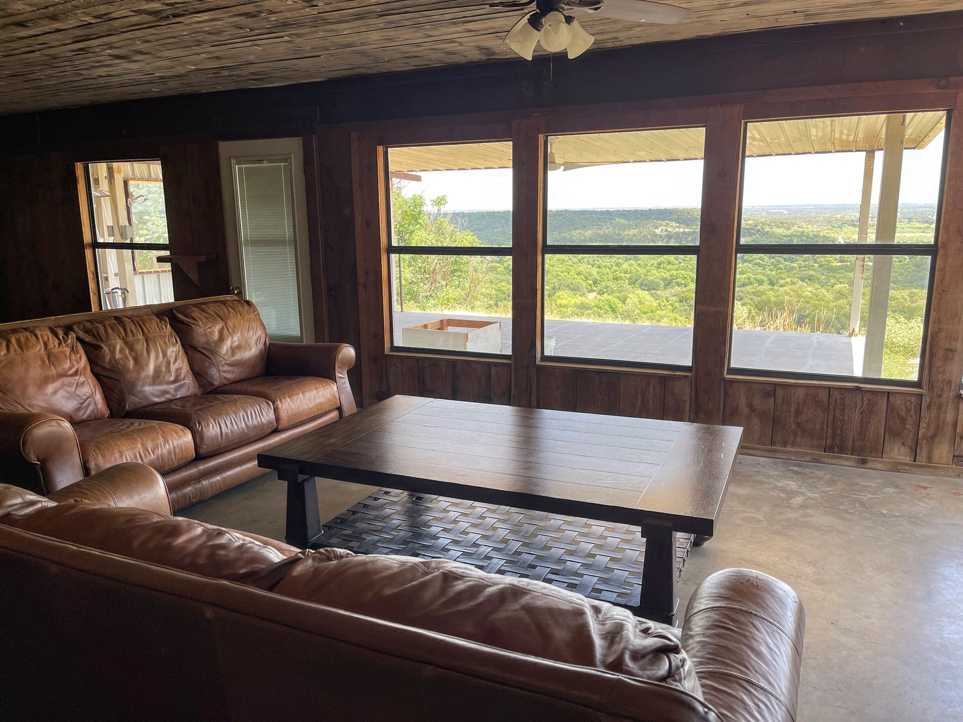 a living room with a couch , coffee table , and large windows .
