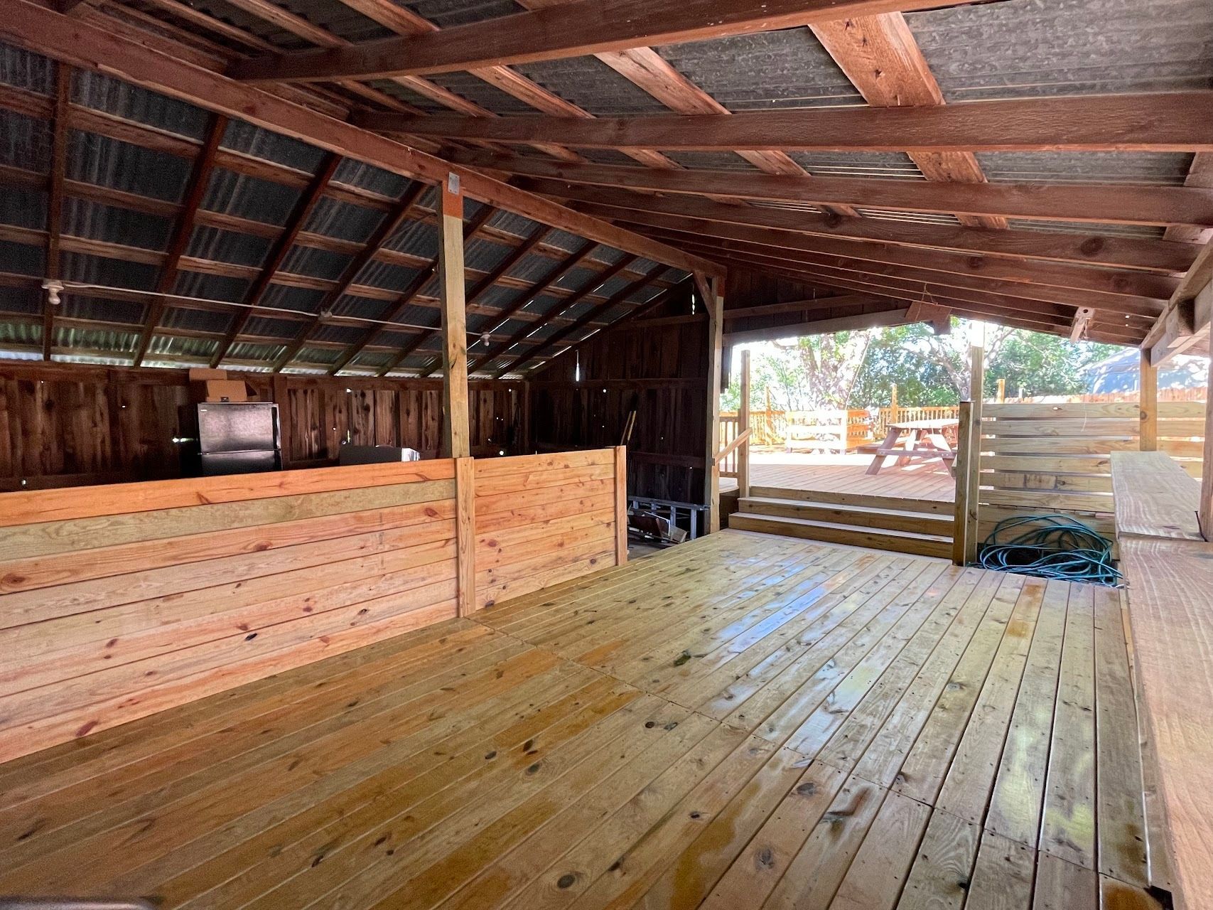 the inside of a wooden building with a wooden deck and a metal roof .
