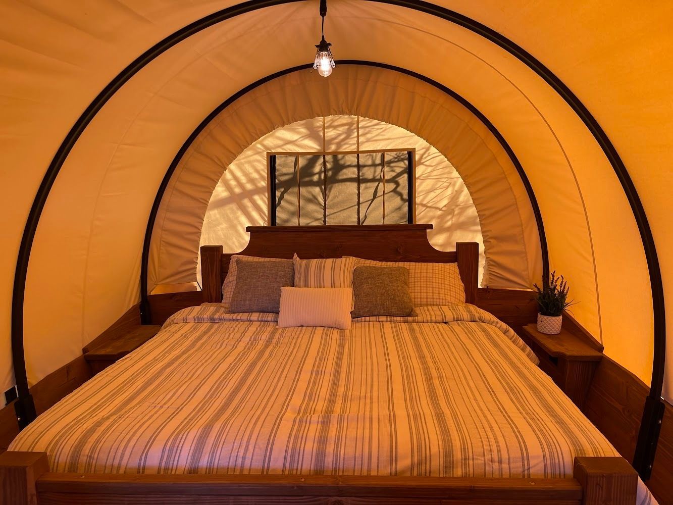 a bed in a tent with a picture on the wall above it
