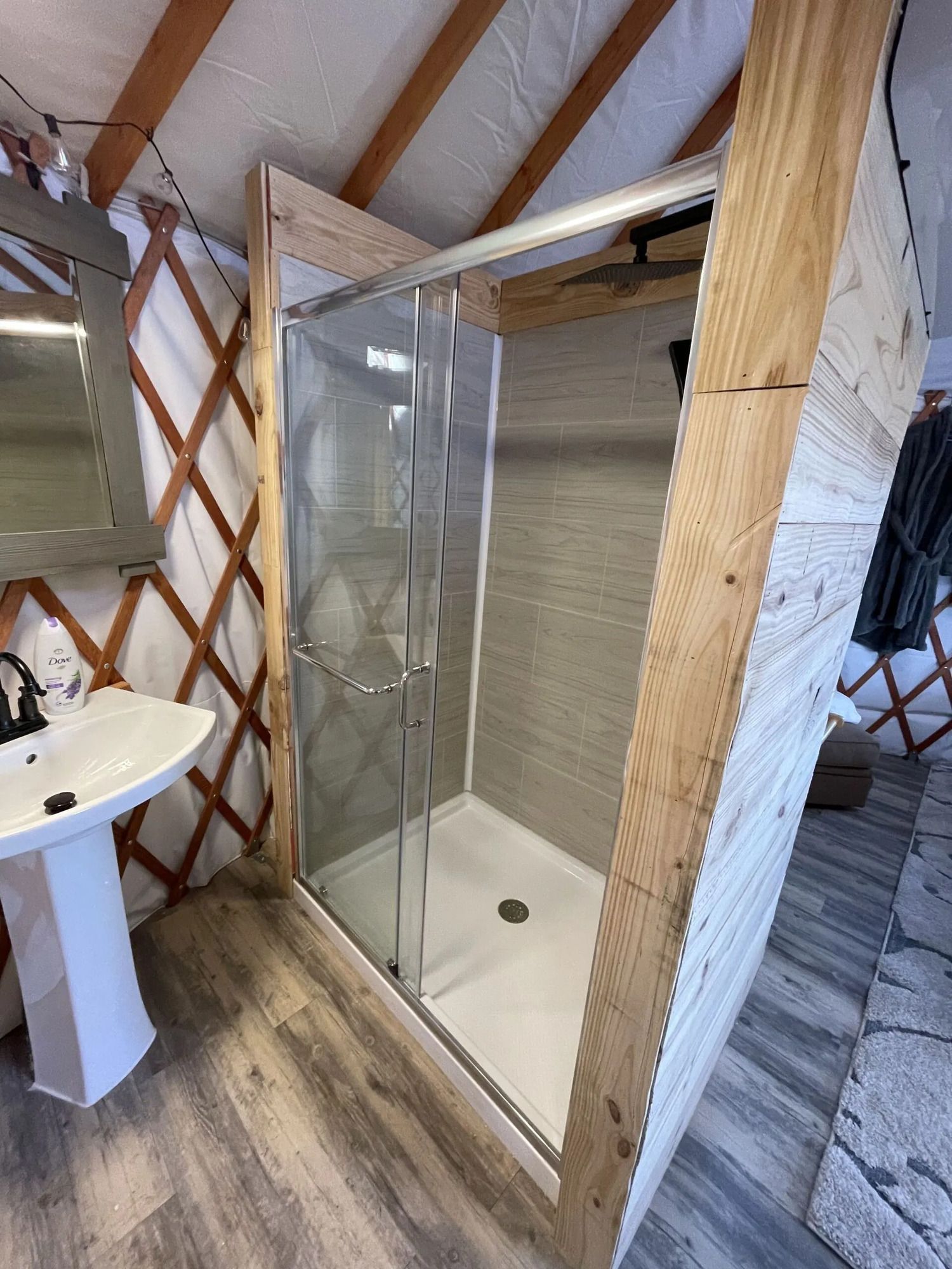 a bathroom with a sink and a walk in shower .