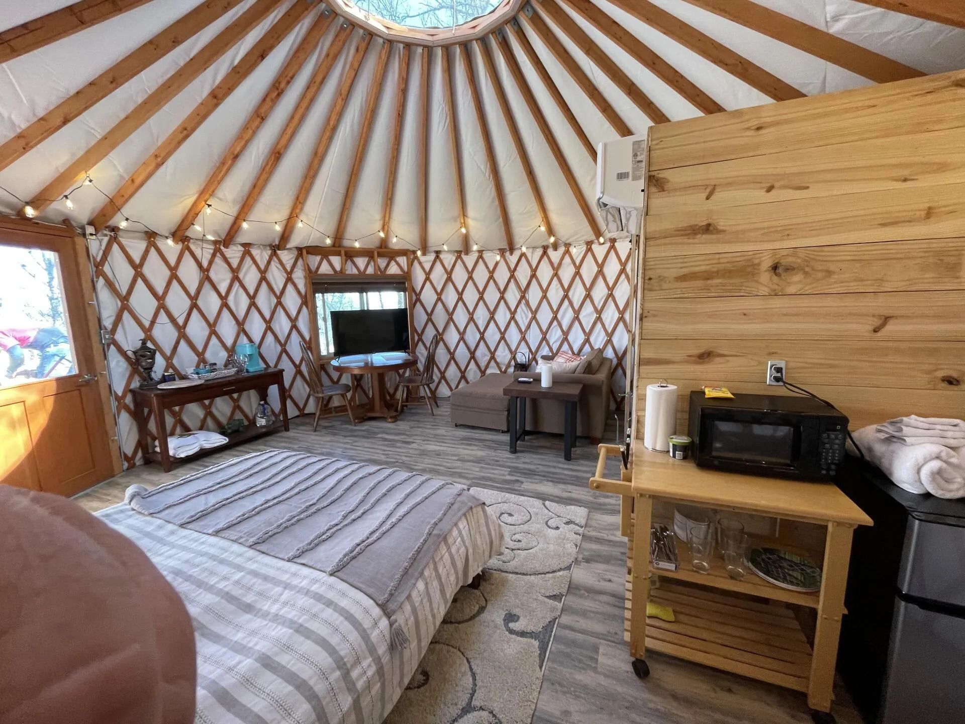 there is a bed in the middle of the room in a yurt .