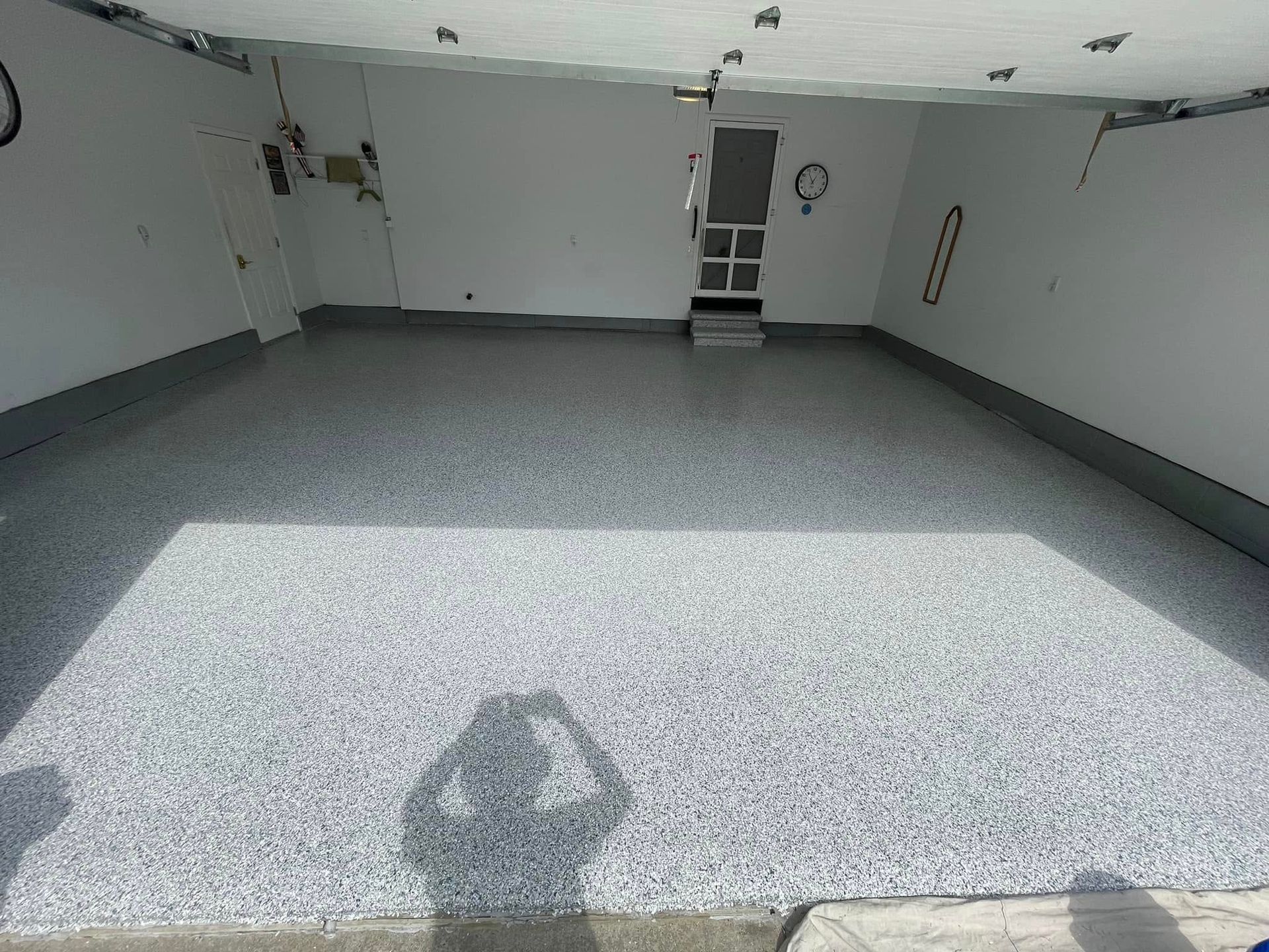 Garage with a gray speckled epoxy floor.