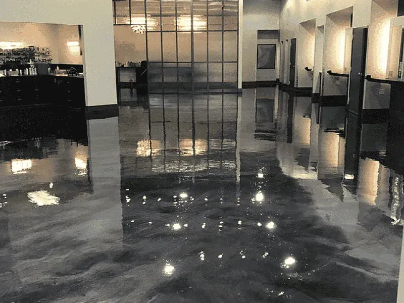 Shiny, reflective epoxy floor in a modern interior. Dark silver and black swirls with light reflections.
