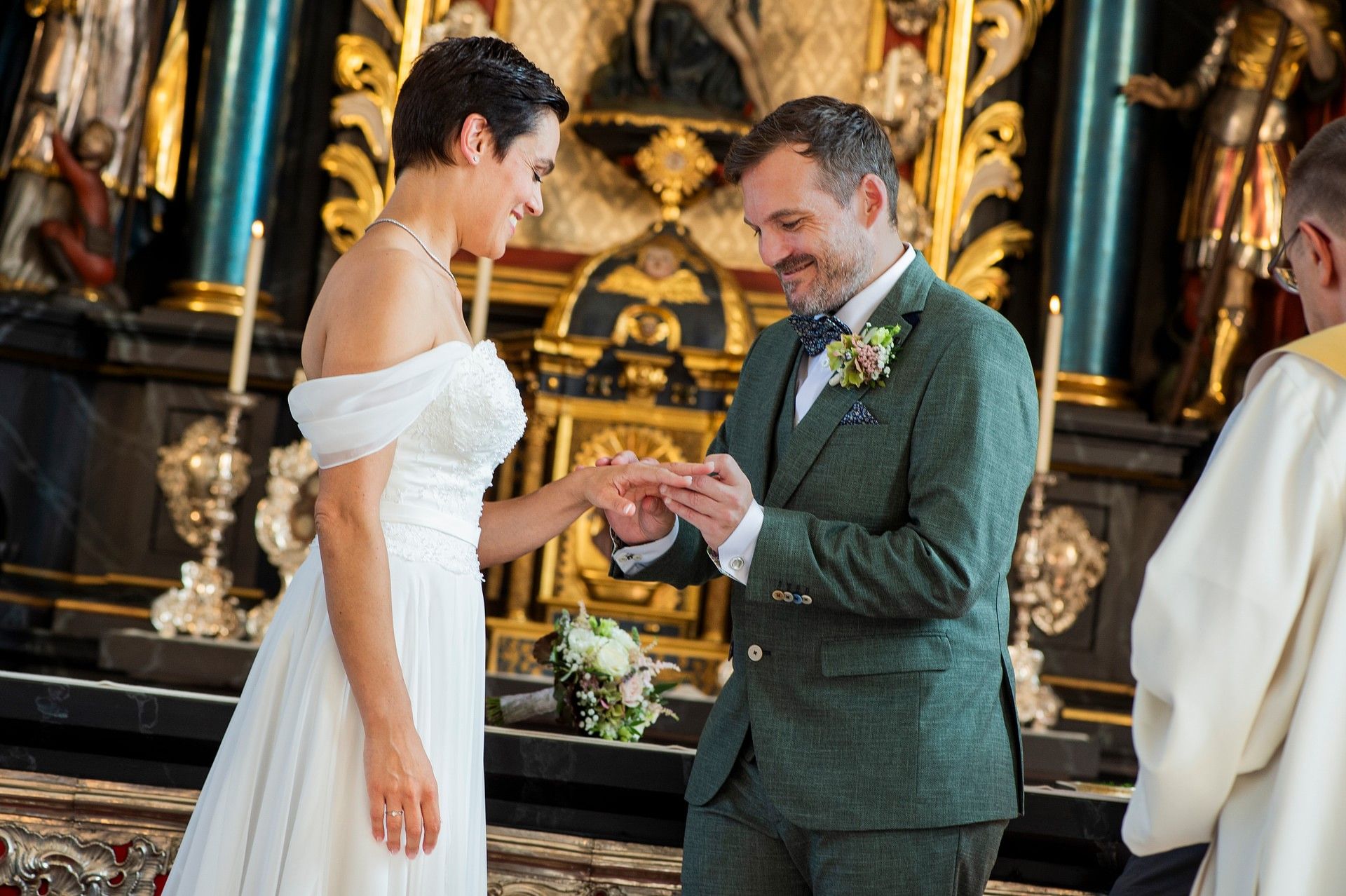 A bride and groom are posing for a picture in front of a body of water.