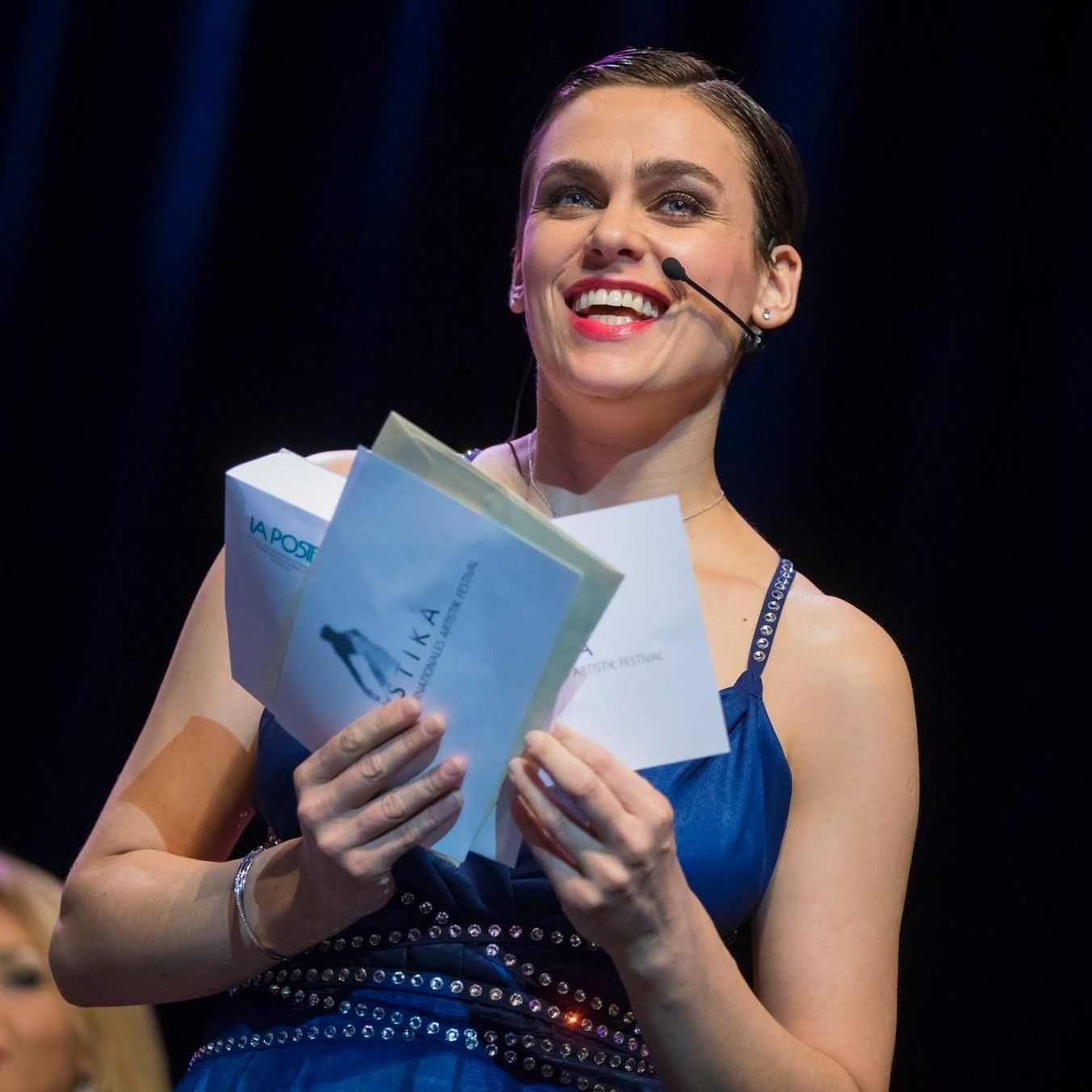 A bride and groom are posing for a picture in front of a body of water.