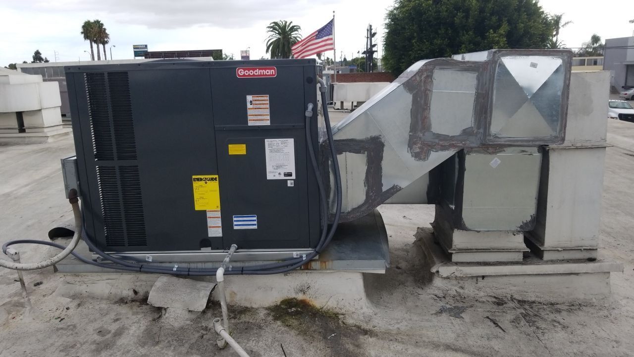 A large air conditioner is sitting on top of a roof.