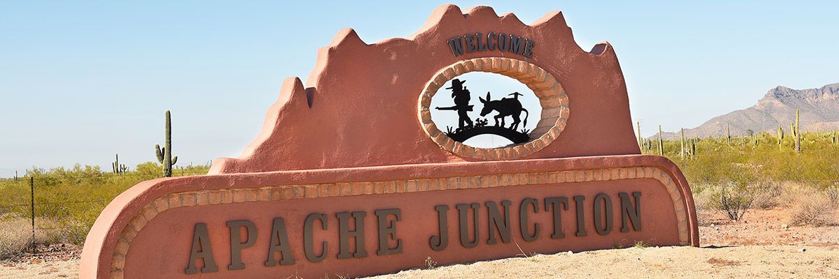a sign that says apache junction in the desert