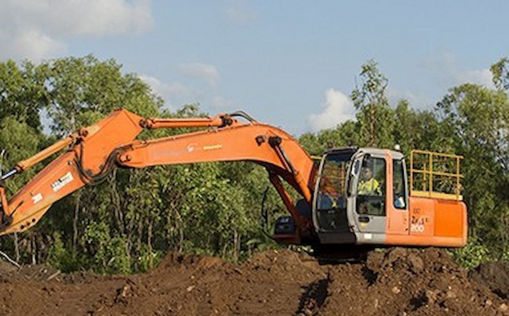 A Large Orange Excavator Is Sitting in A Pile of Dirt — Diggamen Civil Contracting in Tivendale, NT