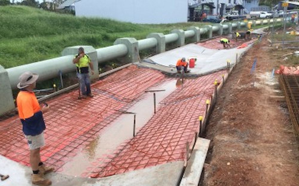 A Person is Installing Drain Pipes in a Trench — Diggamen Civil Contracting in Tivendale, NT