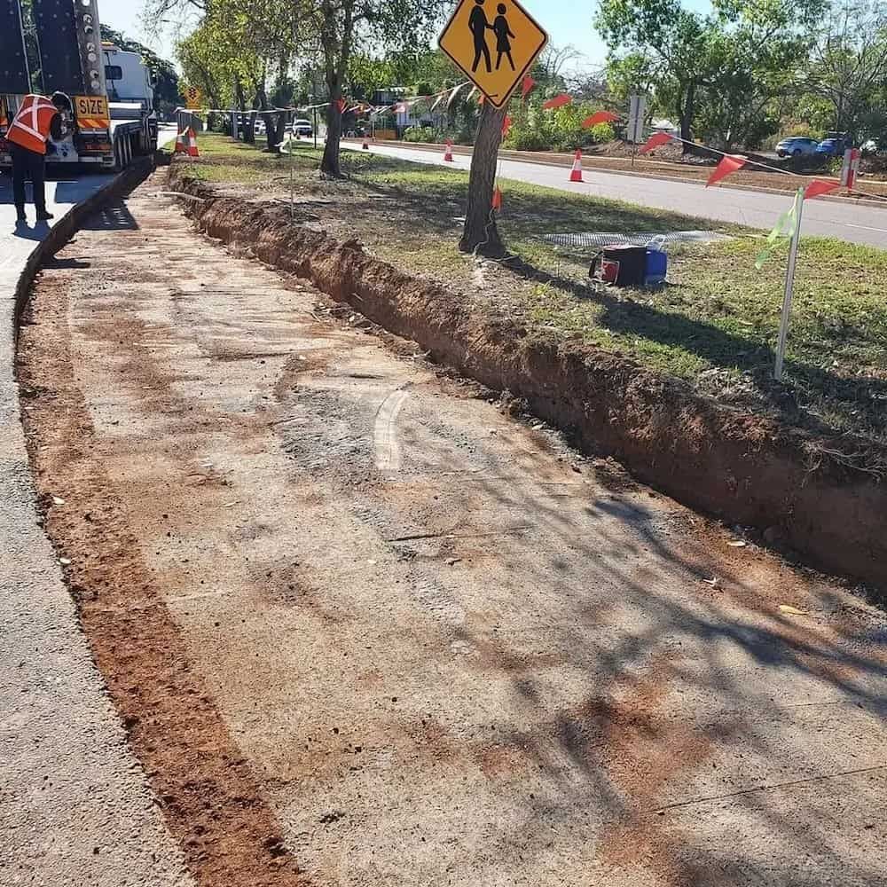 A Yellow School Crossing Sign Is Sitting on The Side of A Road — Diggamen Civil Contracting in Alice Springs, NT