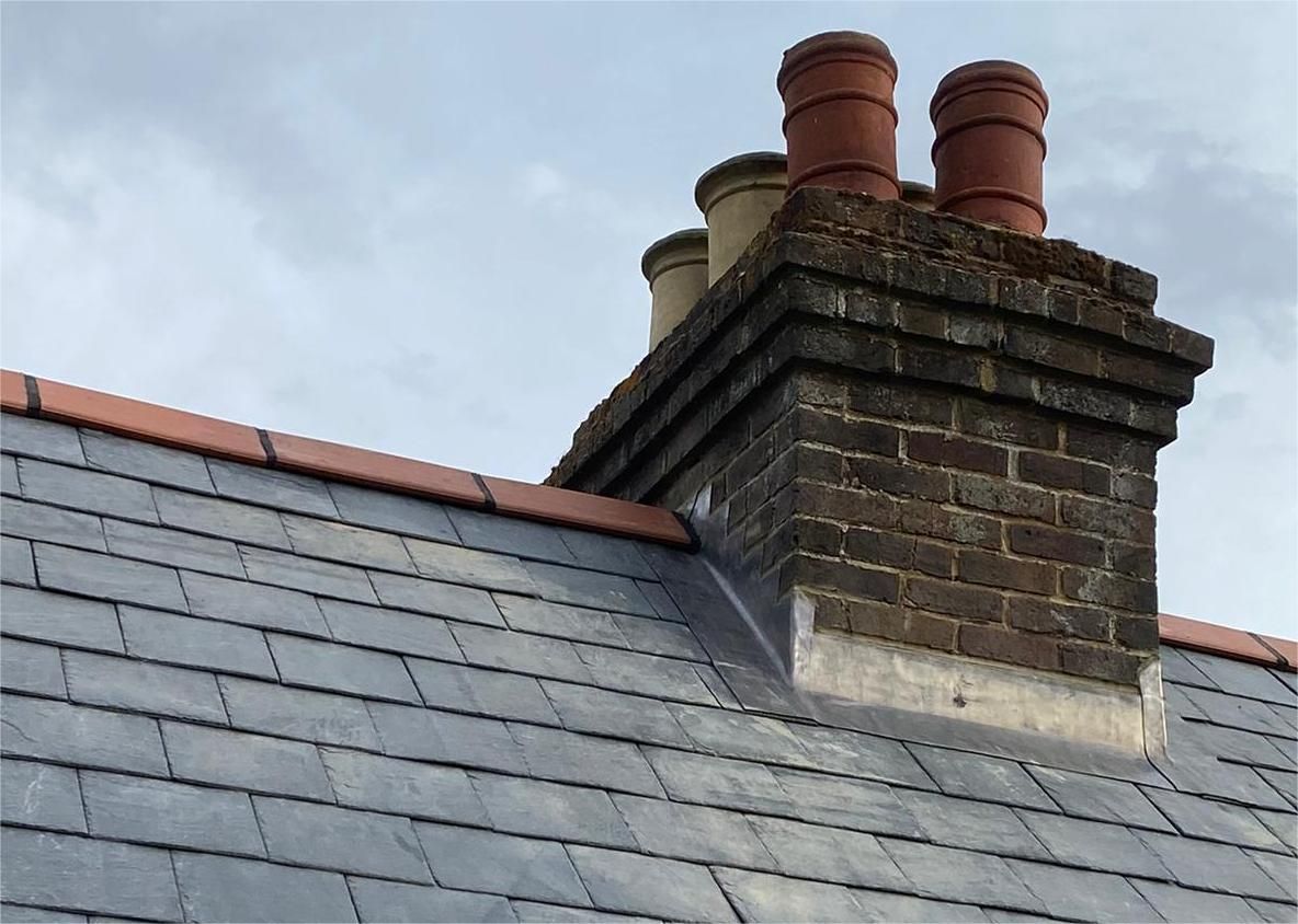 Completed chimney flashing installation ensuring waterproof seal on tiled roof.