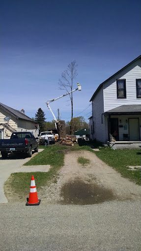 A telephone pole is being installed in a residential neighborhood.