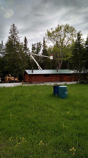 A log cabin is sitting in the middle of a grassy field.