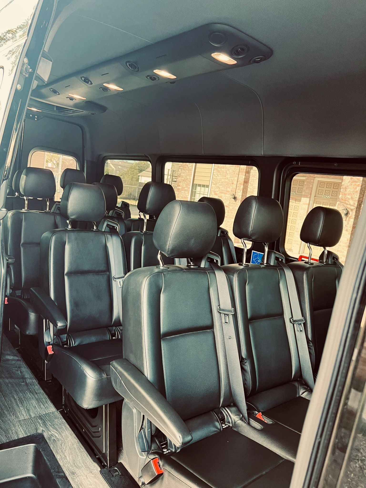 The inside of a van with a lot of seats and headrests.