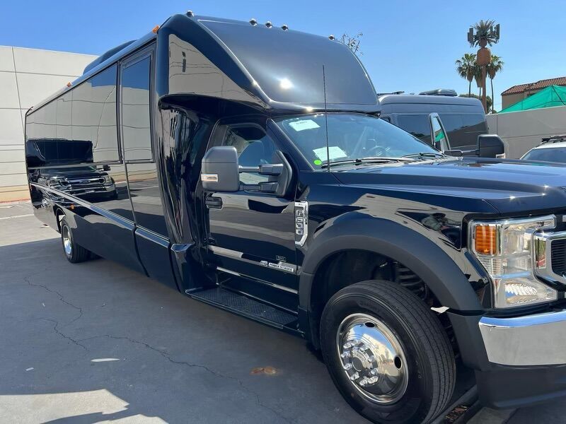 A black truck is parked in a parking lot next to a building.