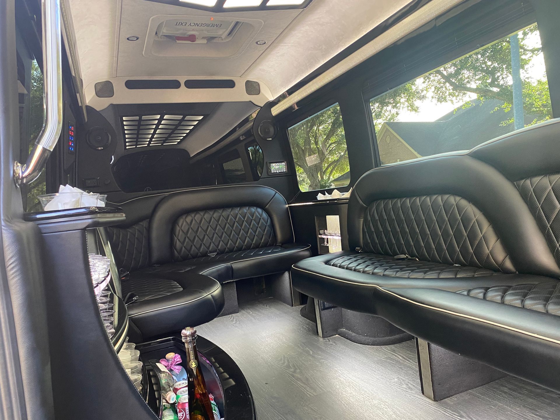 The inside of a limousine with black leather seats and a table.