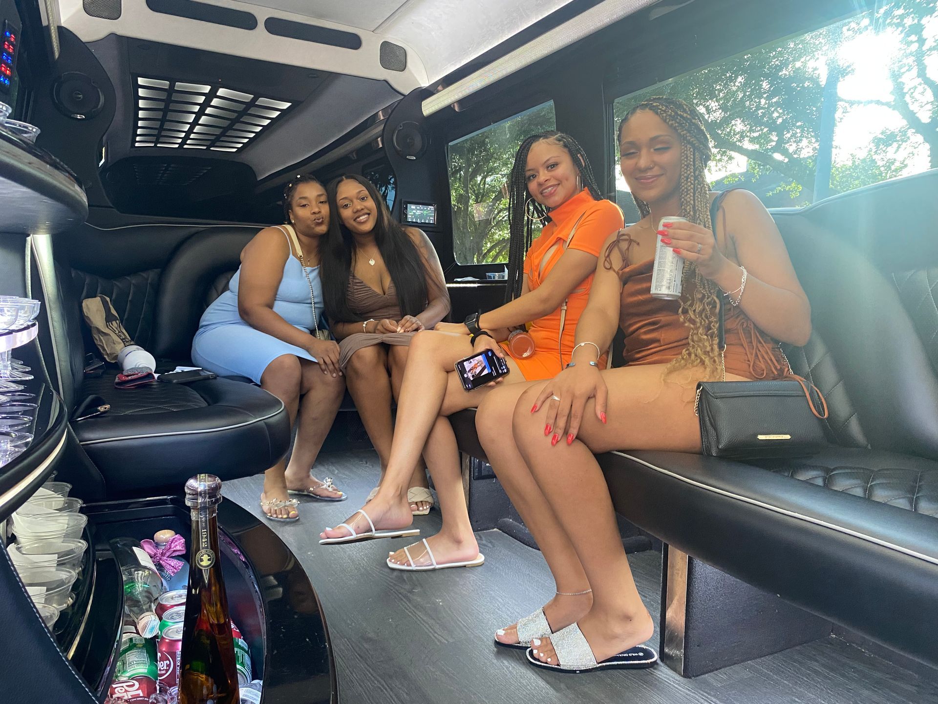 A group of women are sitting in a limousine.