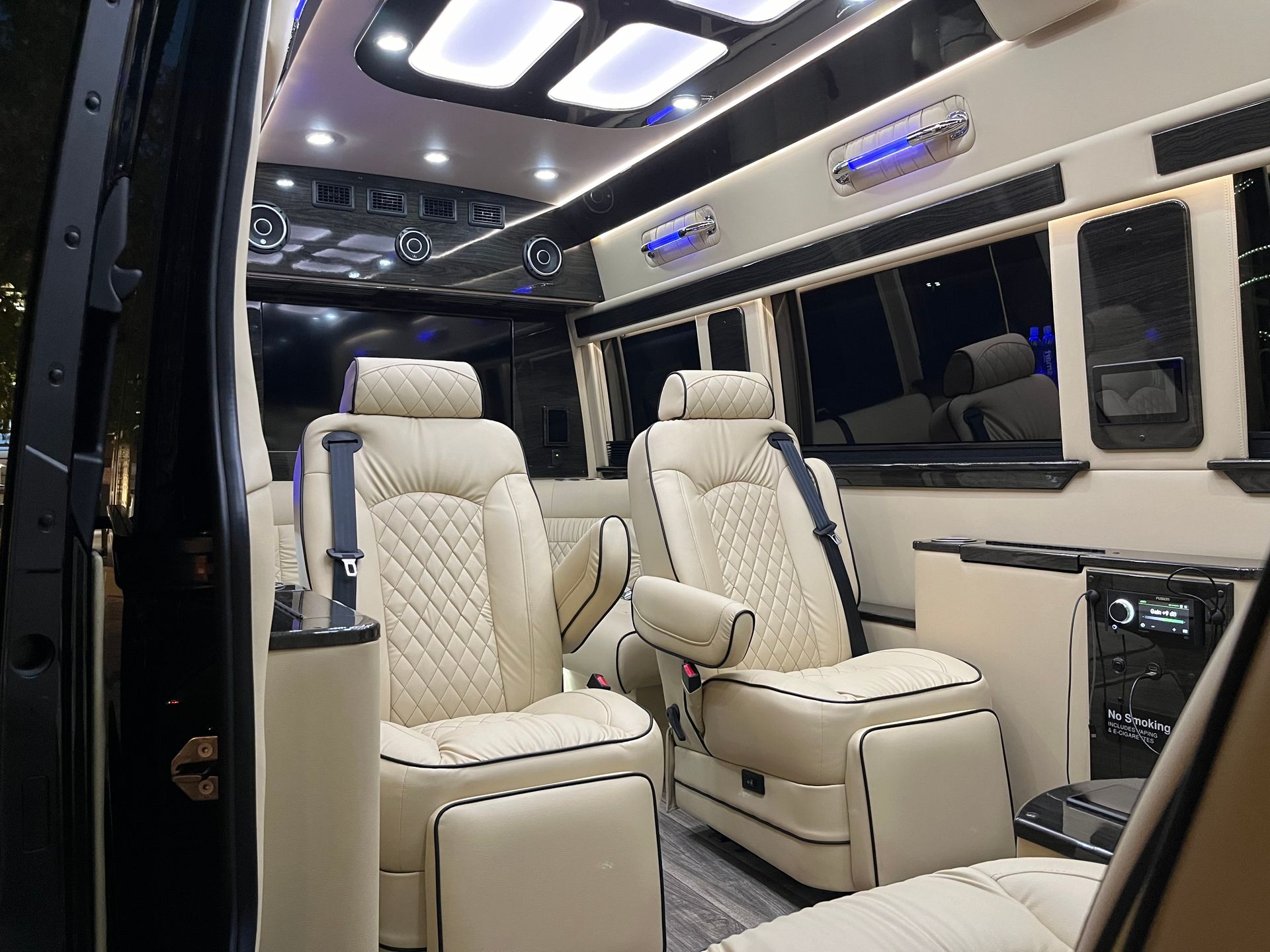 Luxurious van interior with cream leather seating and ambient lighting.