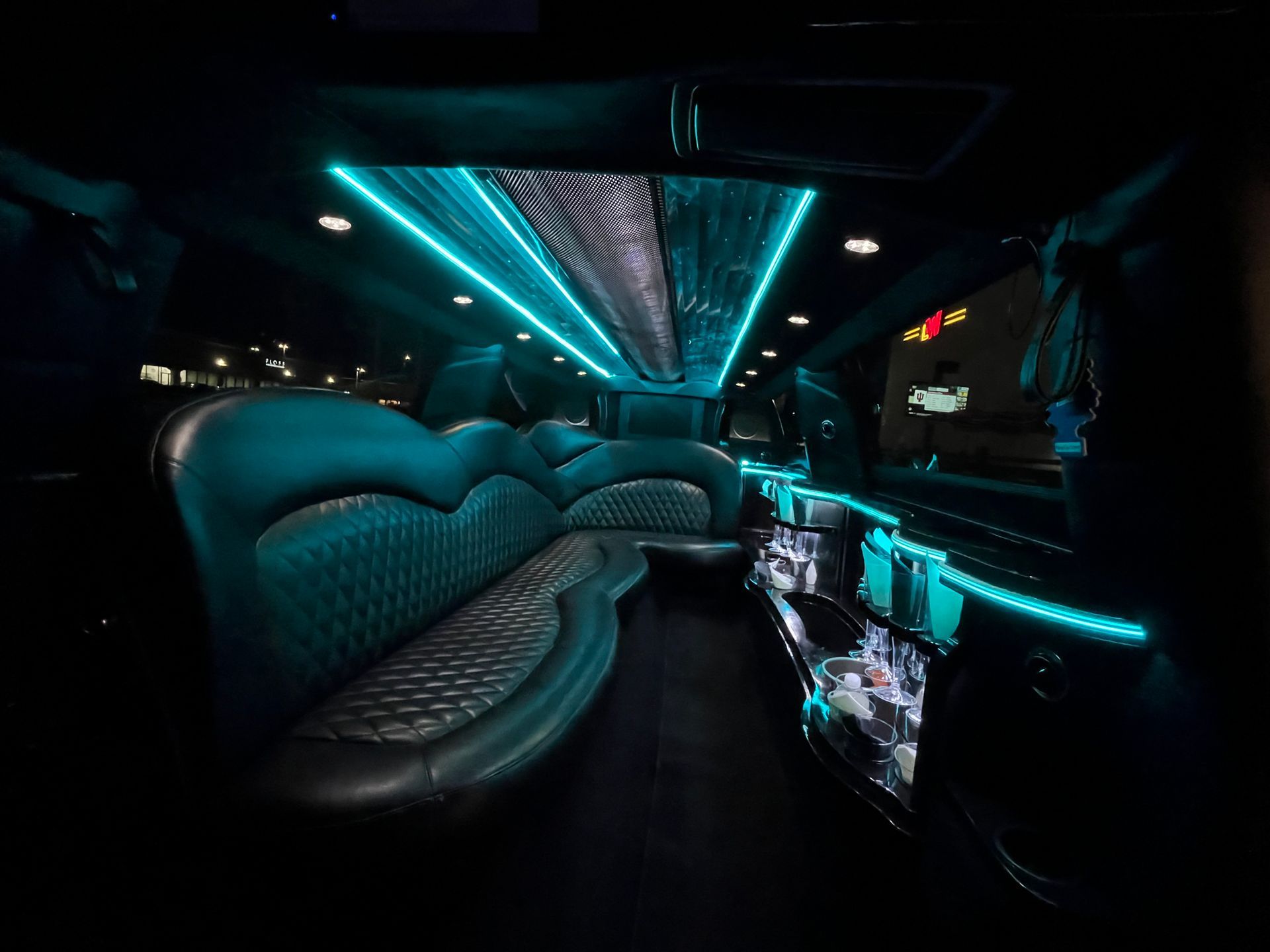The inside of a limousine with blue lights on the ceiling.