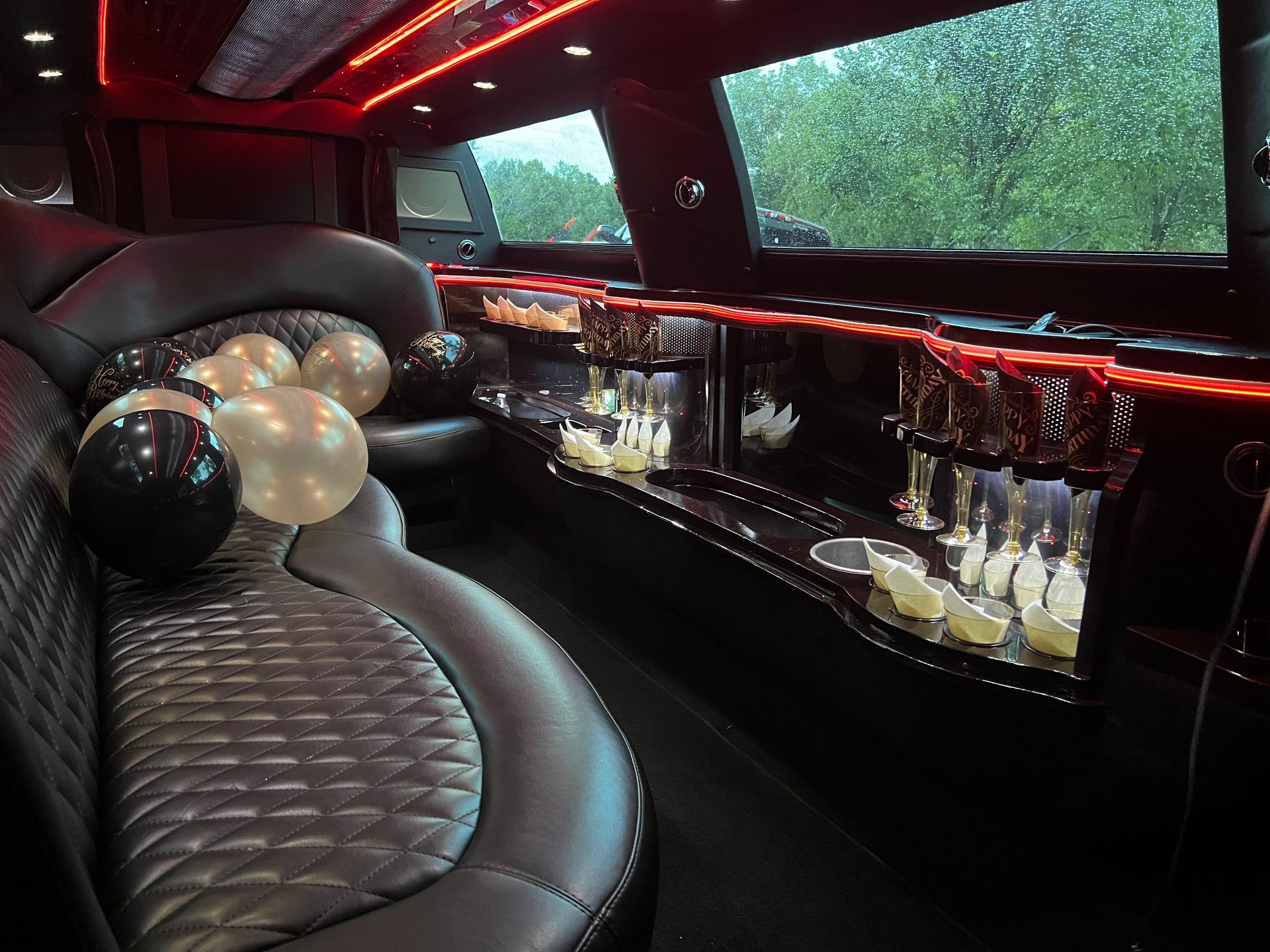 The inside of a limousine with balloons on the seats.