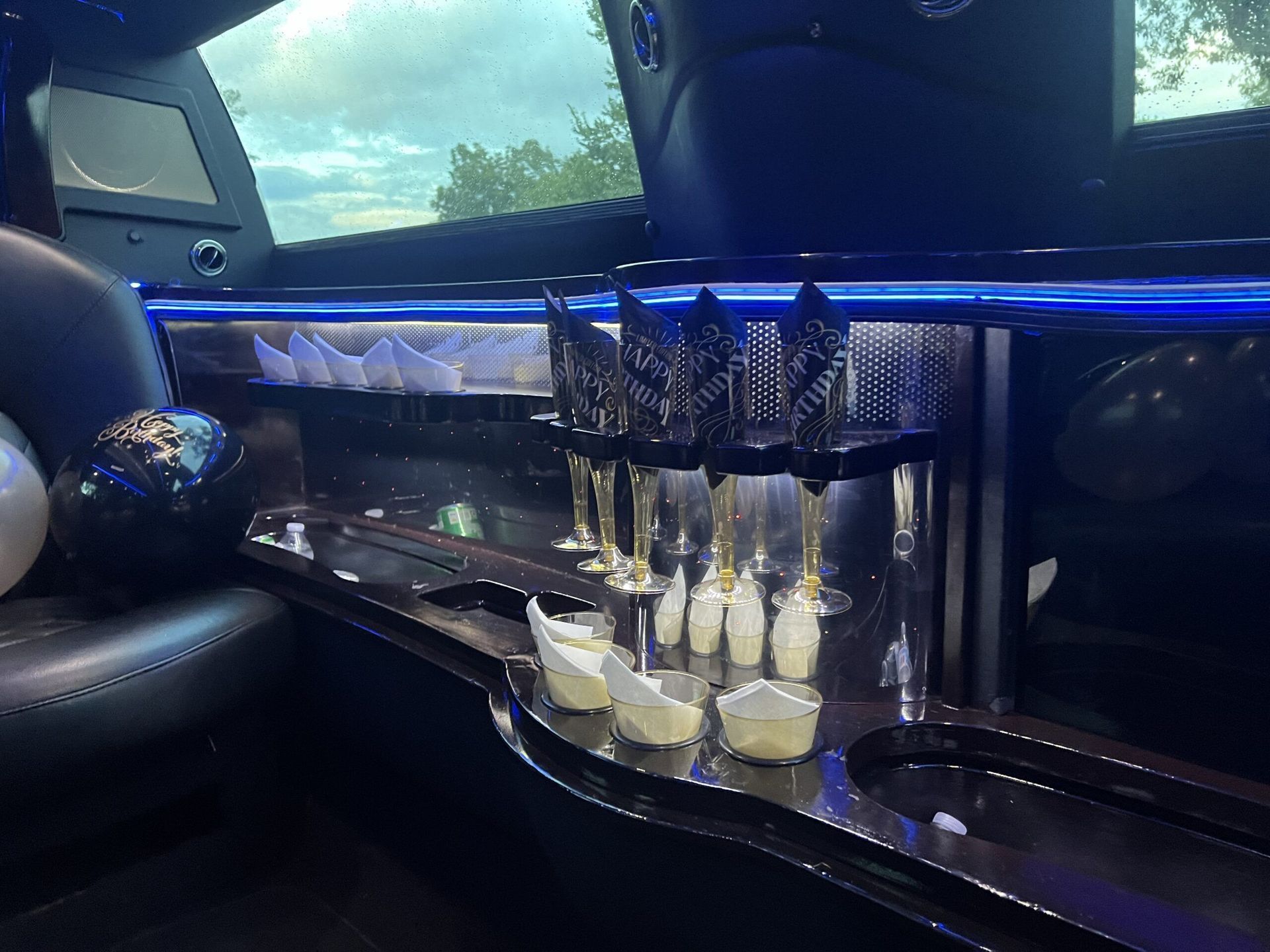 The inside of a limousine with a tray of champagne glasses.