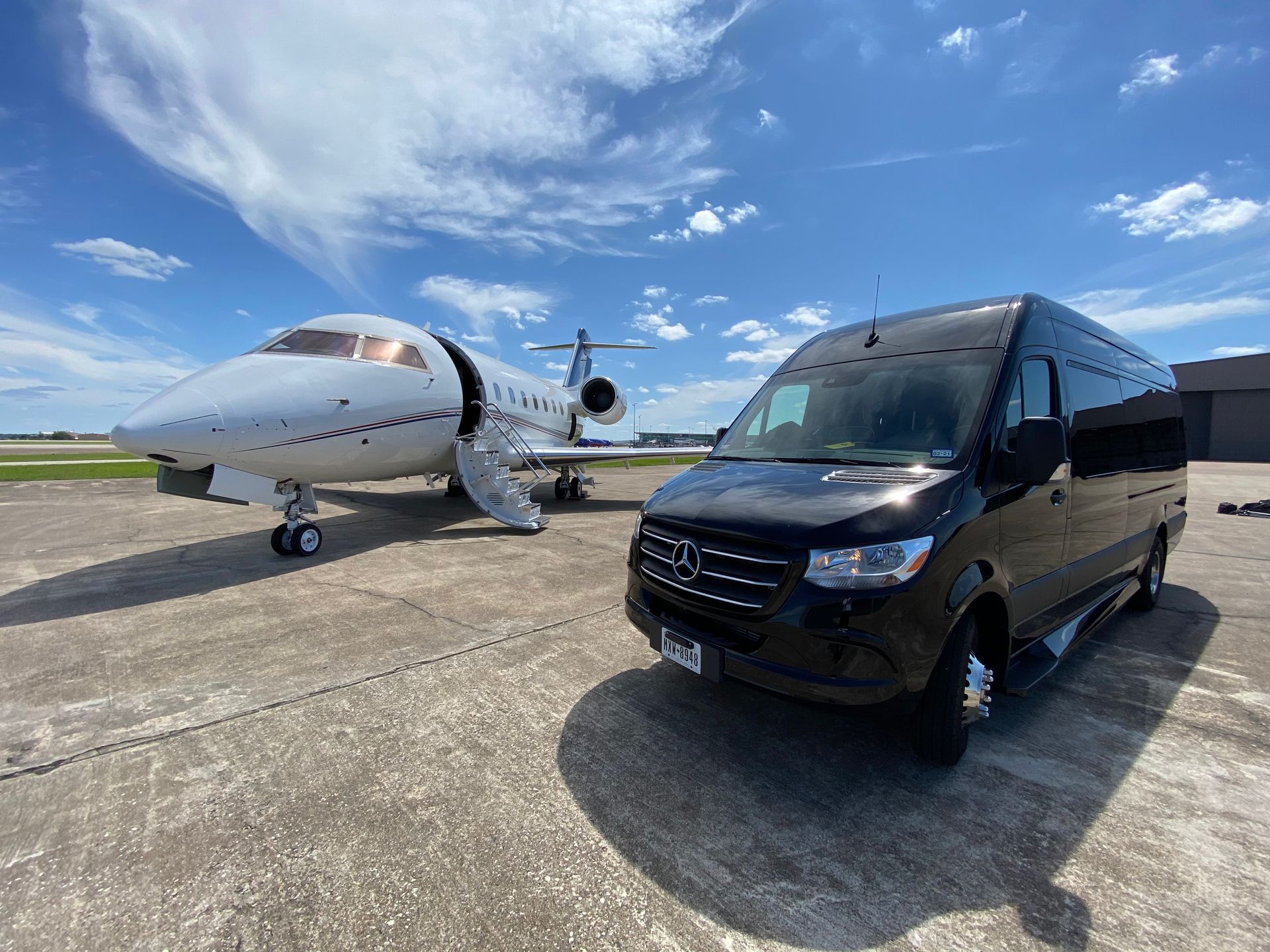 Luxury chauffeured vehicle beside a private jet for IAH airport transportation in Houston