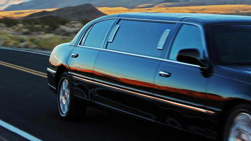 A black limousine is parked on the side of the road.