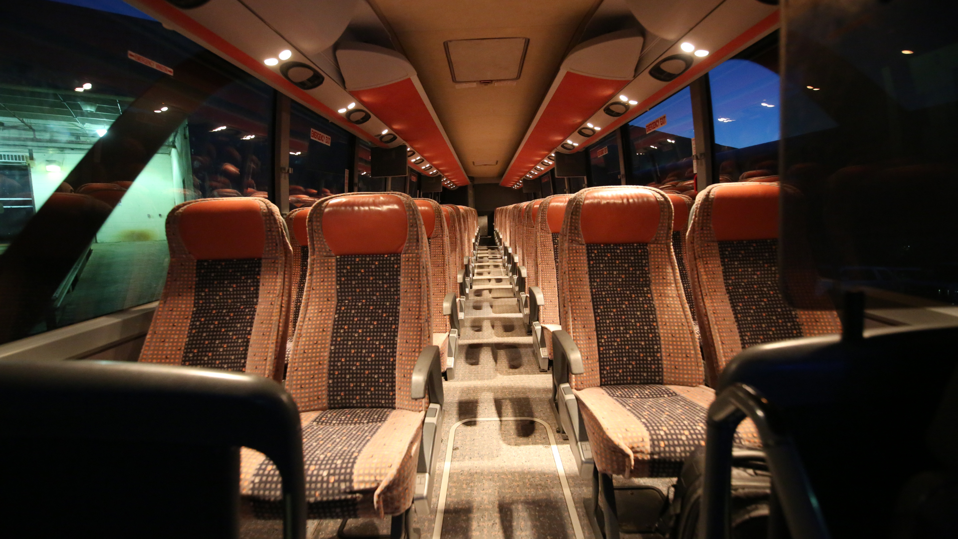 A van and a limousine are parked next to each other in a parking lot.
