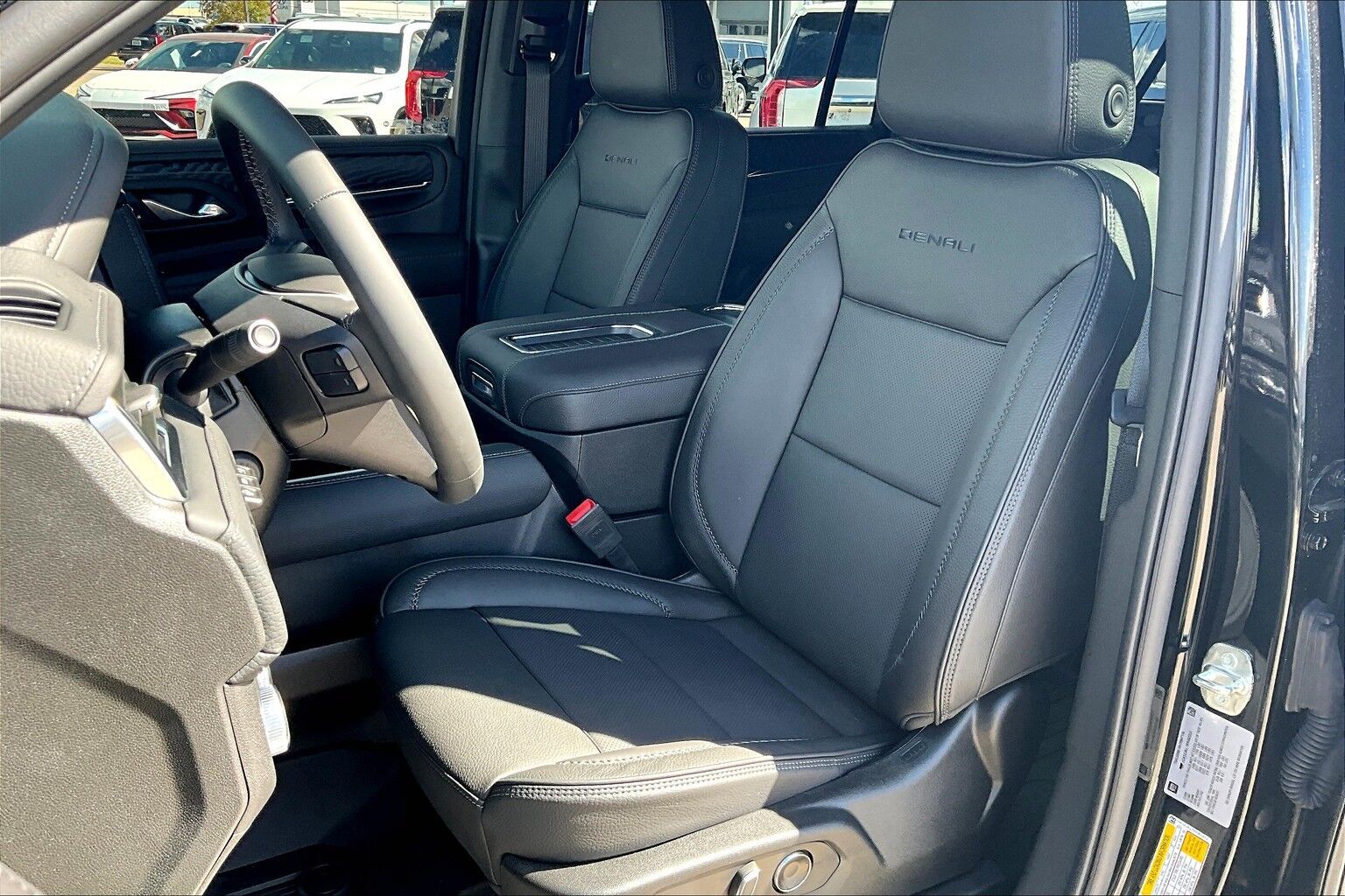 The interior of a black truck with leather seats and a steering wheel.